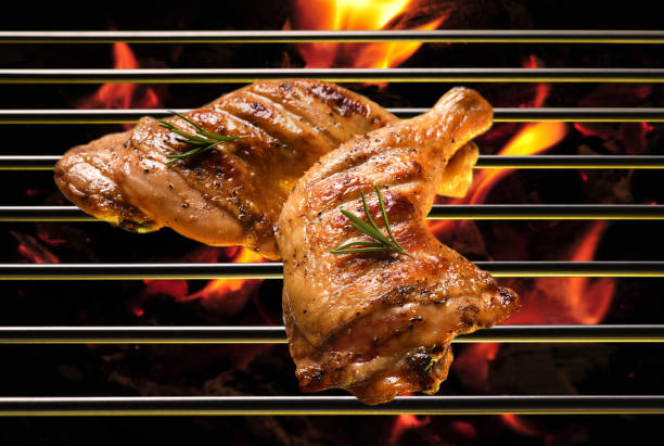 Top view of grill bbq roast chicken thigh on the flaming grill Top view of grill bbq roast chicken thigh on the flaming grill